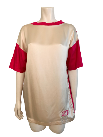 Front view of mannequin wearing an oversized color block t-shirt with pink cotton on sleeves and crème colored silk paneling on front