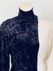 Close up of half black velvet, half white jersey jumpsuit with mock neck by Norma Kamali. 