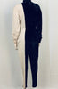 Full length back view of mannequin wearing a Norma Kamali half black velvet, half white jersey jumpsuit. 