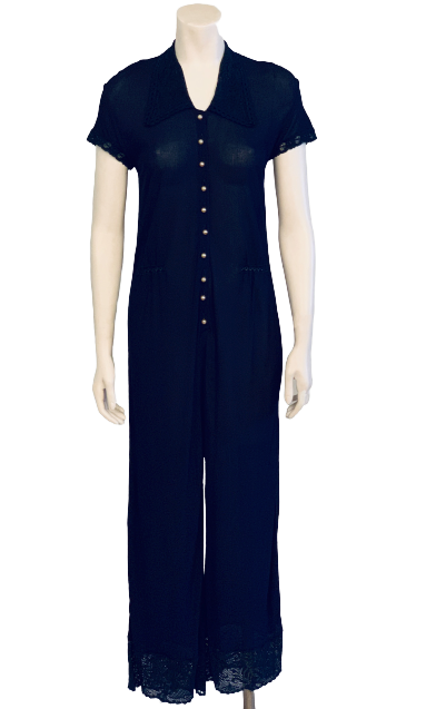 Dark blue, sheer, short-sleeve jumpsuit with pearl buttons and lace-trimmed collar, sleeves, and pant cuffs. 