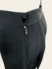 Black, mini-skirt with pleats that run on a diagonal. Triangular button. 