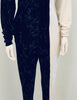 Close up of mannequin wearing a Norma Kamali half black velvet, half white jersey jumpsuit with scrunched long sleeves.