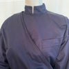 Navy cotton jacket with cropped front and back tails. Front fabric wraps across the body. High neck and cuffed sleeves.