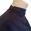 Navy cotton jacket with cropped front and back tails. Front fabric wraps across the body. High neck and cuffed sleeves.