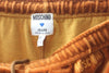 Close up view of authentic "Moschino Jeans" tag inside pants and drawstring elastic waist.