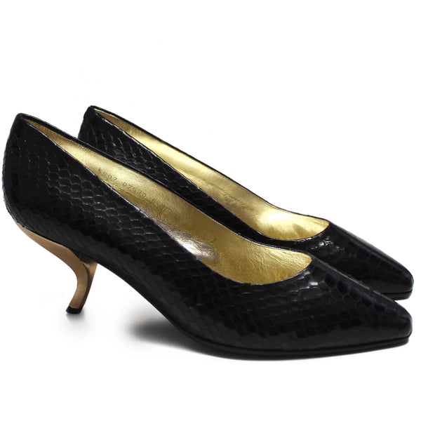 Side veiw of black snake skin shoes featuring gold coma heels  and a gold leather interior